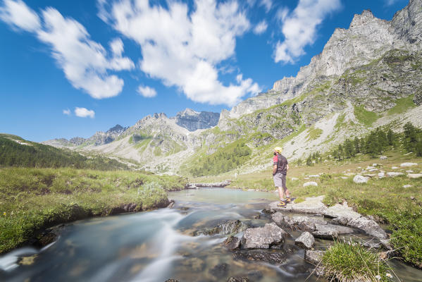 Hiker on the banks of Rio Buscagna, Alpe Devero, Ossola, Piedmont, Italian alps, Italy