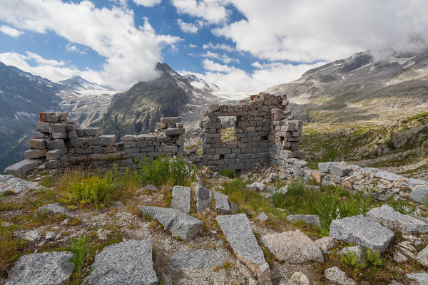 Val Genova, Adamello-Brenta natural park, Trento province, Trentino-Alto Adige, Italy. Remains of the cabin near the Mandrone refuge. In backgroud there are the three Lobbie and the Mandrone's glacier, one of the branches of the Adamello's glacier