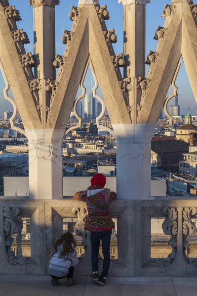 Milan, Lombardy, Italy. Two children observed the Milano's skyline from Cathedral's terrace