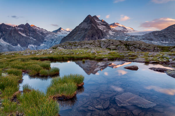 Carisolo, Genova valley, Adamello-Brenta natural park, Trento province, Trentino Alto Adige, Italy. The Three Lobbie and Adamello glacier are reflected at sunset into a small lake near Mandrone refuge