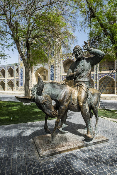 Bukhara, Uzbekistan, Central Asia. The monument to Nasreddin Hodja and the Nadir Divan-Beghi madrasah on the background.