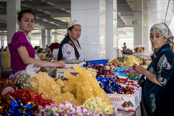 Samarkand, Uzbekistan, Central Asia. A group of women with traditional dress at the grocery market.