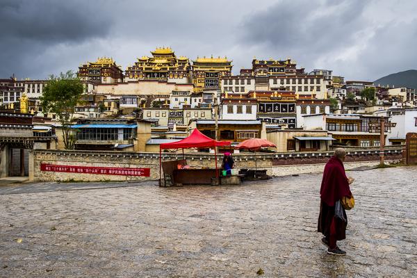 Monk walking in front at the Ganden Sumtseling Monastery, Zhongdian, Shangri-La County, Yunnan Province, China, Asia, Asian, East Asia, Far East