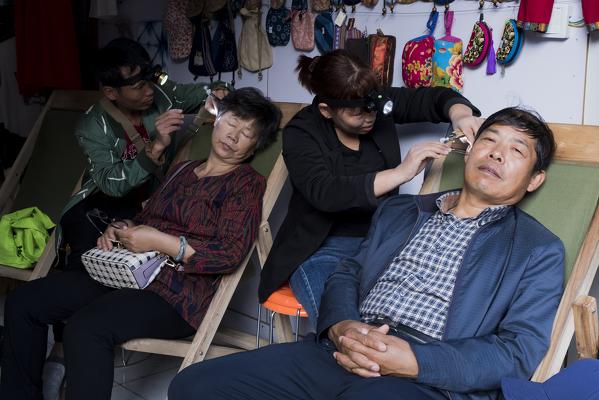 Ear cleaning technicians in old town of Dali, Yunnan Province, China, Asia, Asian, East Asia, Far East