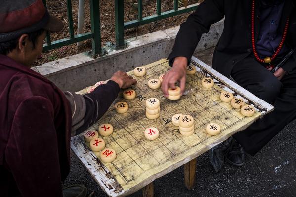 Two people playing in street of Zhongdian, Shangri-La County, Yunnan Province, China, Asia, Asian, East Asia, Far East