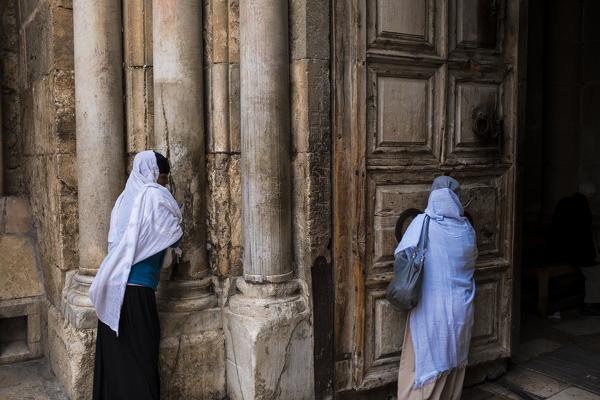 Two women kisses the entrance Church of the Holy Sepulchre, Jerusalem, Israel, Middle East