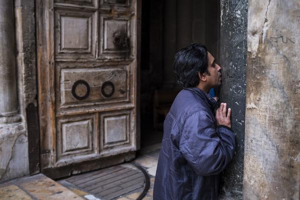 Man kisses the entrance Church of the Holy Sepulchre, Jerusalem, Israel, Middle East