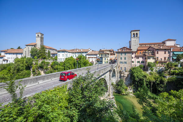 red car passes over the Devil's bridge (Ponte del Diavolo) on the Natisone river, Udine, Friuli Venezia Giulia, Italy, Europe