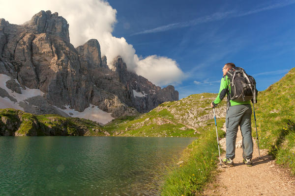 Europe, Italy, Veneto, Belluno. Hiker passes near Lake Coldai along the CAI 560, which at this point coincides with the Alta Via n. 1 of the Dolomites.