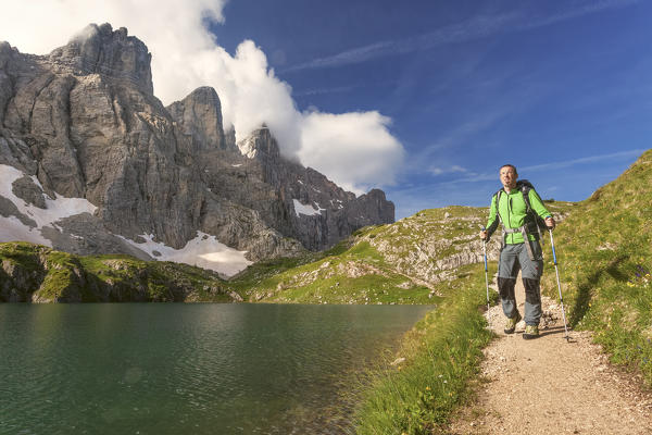 Europe, Italy, Veneto, Belluno. Hiker passes near Lake Coldai along the CAI 560, which at this point coincides with the Alta Via n. 1 of the Dolomites.