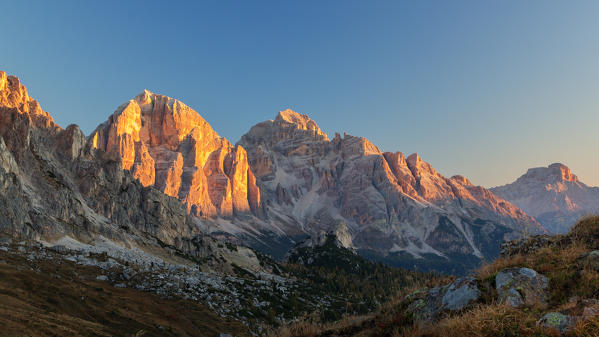 The south side of the Tofane (Dolomites) lighted by the first rays of sun in a clear autumn morning with blue sky. Giau pass, Belluno, Veneto, Italy