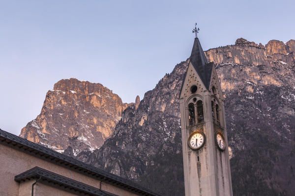 The bell tower of the parish church of Taibon Agordino with behind the south wall of the Pale di San Lucano. In evidence the Besausega tower, Dolomites, Europe, Italy, Veneto, Belluno 