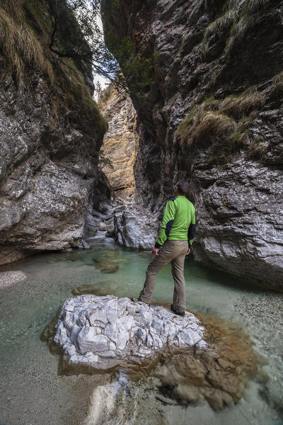 Hiker observes the gorge of the Val Soffia, above the waterfall. Monti del Sole, Belluno Dolomites National Park