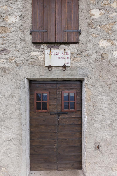 The casera Nusieda Alta, one of only three support points for hikers in the vast area of the Monti del Sole, here a detail of the entrance door with the plate of the name and the altitude. Monti del Sole, Dolomiti Bellunesi National Park, Belluno, Veneto, Italy