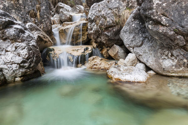 Small waterfalls of turquoise water in val Salet, Monti del Sole, National park Belluno Dolomites, Italy
