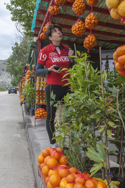 Woman on the roadside fruit and vegetable stand near Komin, Croatia.