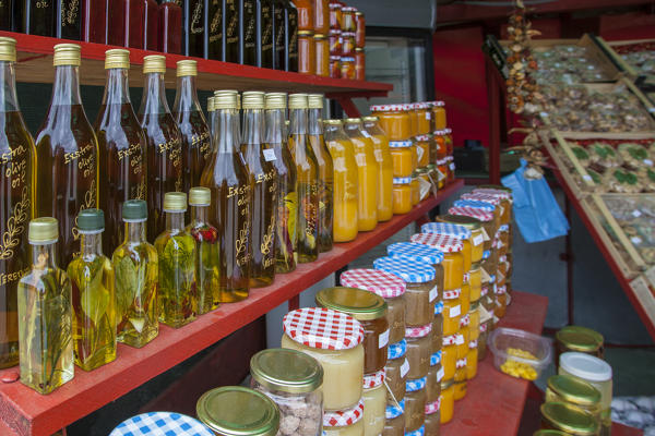 Bottles of olive oil, marmalade, honey, for sale in a market of local products along the road near Komin, Croatia