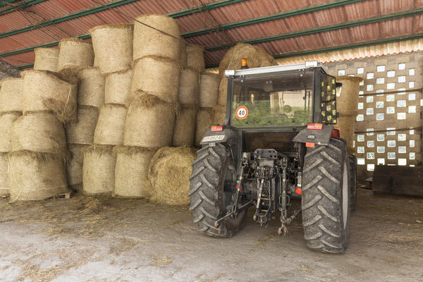 Tractors, equipment and bales of hay in the shed in front of the stables of Case Salet, State Natural Reserves, Monti del Sole