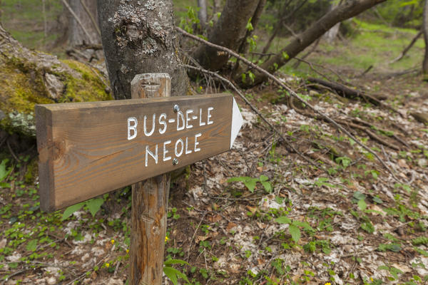 Wooden table with the direction to the Bus de le Neole, Dolomitipark, Belluno, Dolomites