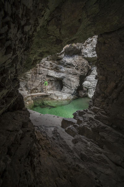 Dolomites, Belluno, Veneto, Italy. Man exploring the gorge of the Soffia waterfall, Mis valley