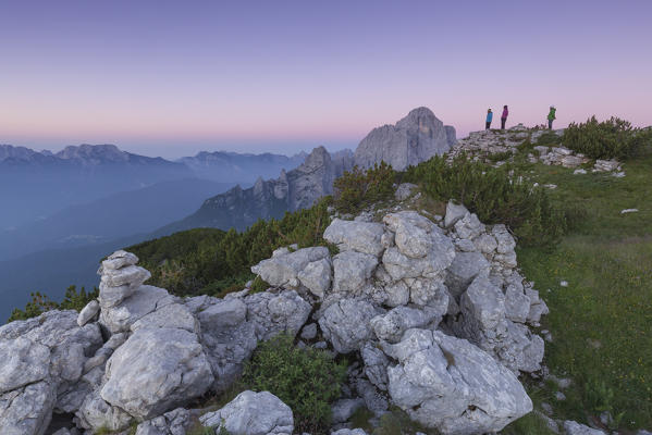 Europe, Italy, Veneto. Hikers on the First Pala di San Lucano summit  looking the sunrise. Agordo Dolomites, Belluno, Italy