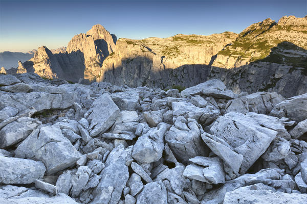 Stony ground on First Pala di San Lucano, in the background mount Agner and Seconda Pala at sunrise. Dolomites, Agordino, Belluno, Veneto, Italy, Europe