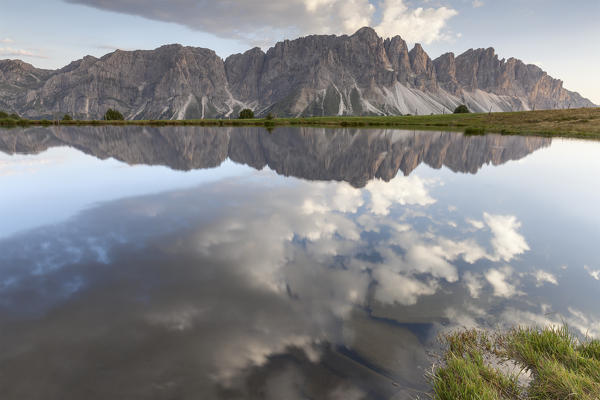 Europe, Italy, South Tyrol, Bolzano. Odle di Eores (Aferer Geisler) reflected in the Wackerer lake at sunset, Dolomites