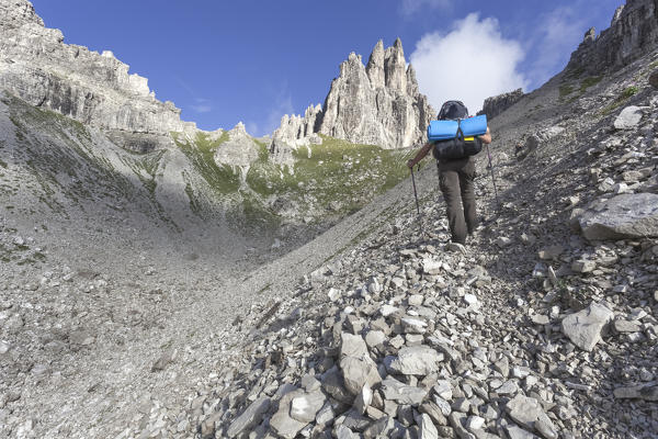 Hiker go up the valley towards the Monfalcon Forni and the fork of the same name. Friulian Dolomites and Oltrepiave, Pordenone