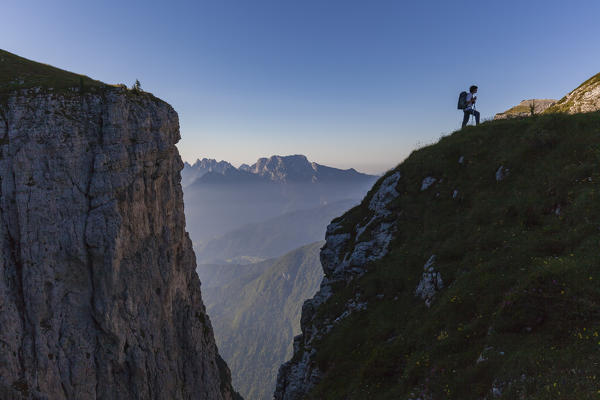 Hiker in silhouette near fork Besausega, Dolomites, Pale di San Lucano, Agordino, Belluno, Veneto, Italy, Europe