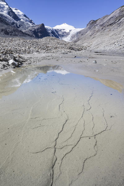 Europe, Austria, Carinthia, Glockner Group, High Tauern. Johannisberg mountain reflected in the water on the gravel moraine of the glacier Pasterze at Grossglockner
