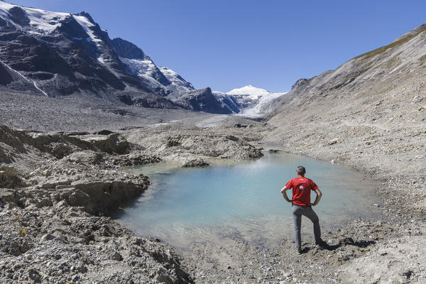 Europe, Austria, Carinthia, Glockner Group, High Tauern. A man lookin to Johannisberg mountain near a water pond on the Pasterze glacier at Grossglockner