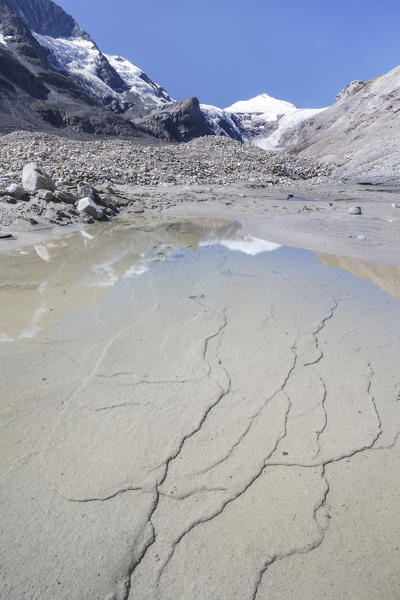 Europe, Austria, Carinthia, Glockner Group, High Tauern. Johannisberg mountain reflected in the water on the gravel moraine of the glacier Pasterze at Grossglockner