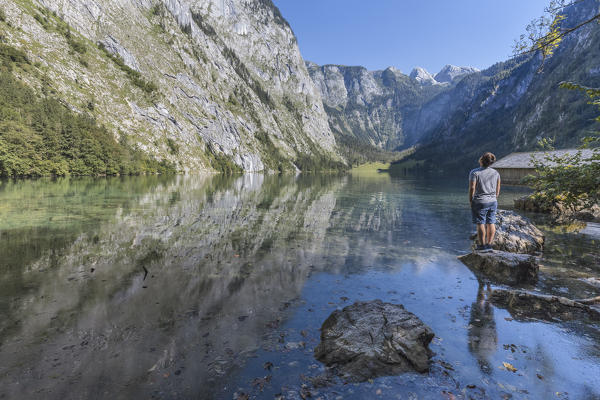 Europe, Germany, Bavaria, Berchtesgaden. A man looking the scenary of Obersee alpine lake in the Alps
