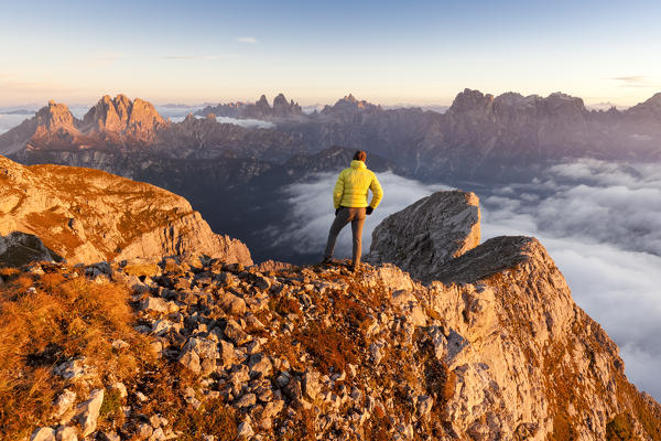 Europe, Italy, Veneto, Cadore, Auronzo. From Cima dei Camosci, Marmarole, a hiker at sunrise is looking towards the sexten dolomites