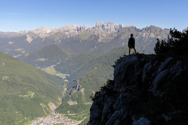 Europe, Italy, Veneto, Agordino, Dolomites, mountaineer silhouette towards the village of Cencenighe Agordino and the Biois valley