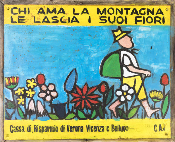 Europe, Italy, Veneto, Agordino, Dolomites. Vintage sign along a path, anyone who loves the mountain leaves her flowers
