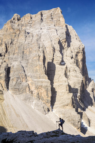 South Tyrol, Sexten, Bolzano. Hiker in silhouette in front of the north east wall of Croda dei Toni, Sexten Dolomites