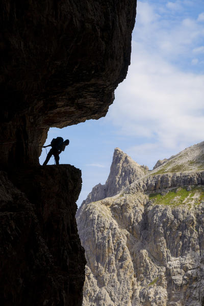 Italy, South Tyrol, Sexten, Hochpustertal, Bolzano. Hiker in silhouette on the Alpinisteig or Strada degli Alpini via ferrata, Sexten Dolomites