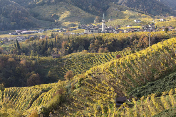 the village of Guia surrounded by the yellow vineyards in autumn, as seen from the road of wine, Valdobbiadene, Treviso, Veneto, Italy