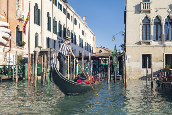 A gondolier rowing a Gondola on the Grand Canal, Venice, Veneto, Italy