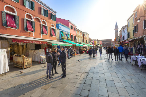 Tourists shopping, colorful stores and restaurants in Via Baldasarre Galuppi, Burano, Venice, Italy