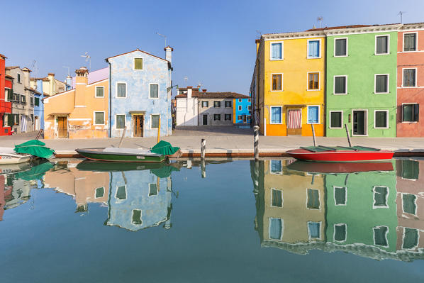 colorful houses in Burano reflected in the water canal, Venice, Veneto, Italy