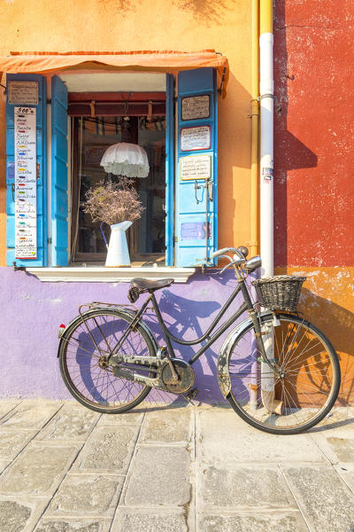 Colorful house facade in Burano island with old bike, Burano, Venice, Veneto, Italy