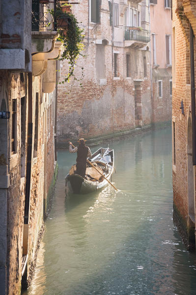 Gondola and gondolier in a small venetian canal, Venice, Veneto, Italy