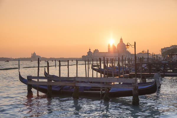 The Grand Canal with Gondolas dock, lamp post and Basilica of Saint Mary of Health at sunset, Venice, Veneto, Italy