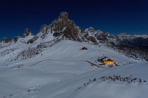 Europe, Italy, Veneto, Belluno. Classic view on the Giau pass in a winter night, the Gusela of Nuvolau and the little hut illuminated. Dolomites