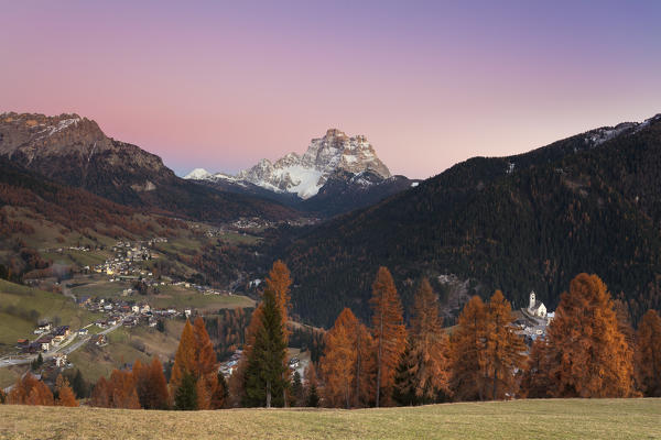 The villages of the Fiorentina valle: Selva di Cadore, Santa Fosca, Pescul and right through the larch trees the church of Colle Santa Lucia. Europe, Italy, Veneto, Dolomites