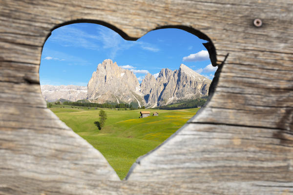 alpine landscape of the Seiser Alm seen through a window with the shape of a heart, Alpe di Siusi/Seiser Alm, Dolomites, South Tyrol, Italy