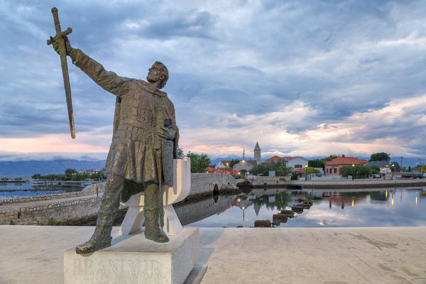 monument of Branimir of Croatia in Nin, on the background the old bridge that connects the old town to the mainland, Nin, Zadar county, Dalmatia, Croatia