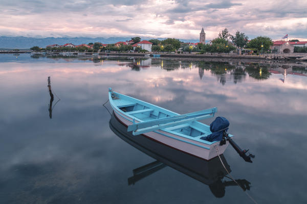 small fishing boat anchored in the bay in front of Nin, in the background the mountains of the Velebit, Nin, Zadar county, Dalmatia, Croatia